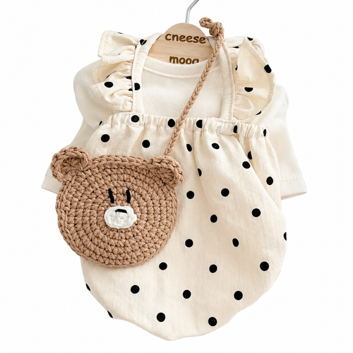Cream polka dot pet dress with ruffled sleeves and bear face crocheted bag by PetoPop, front view on hanger